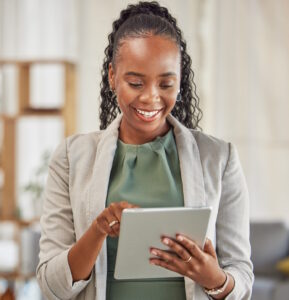 Lawyer, happy or black woman with tablet in office for legal research, online app and social media. News, technology or professional African attorney reading business email, networking or internet.